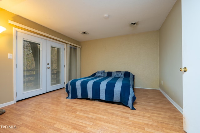 bedroom featuring access to exterior, french doors, and light hardwood / wood-style flooring