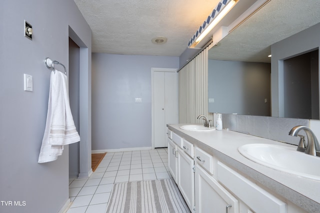 bathroom featuring tile patterned flooring, vanity, and a textured ceiling