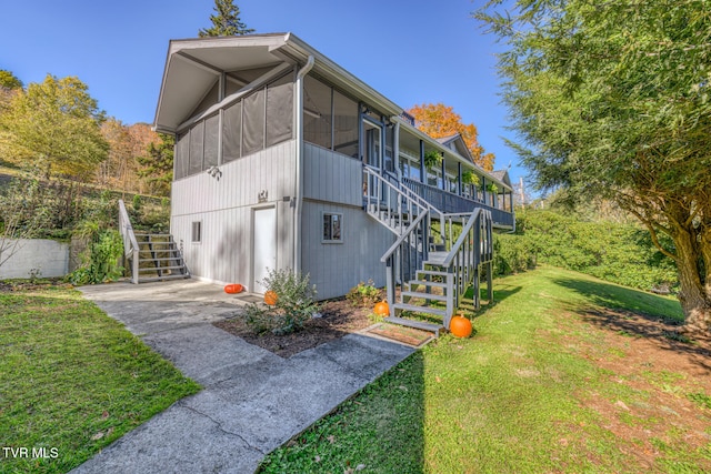 view of side of home featuring a yard and a sunroom