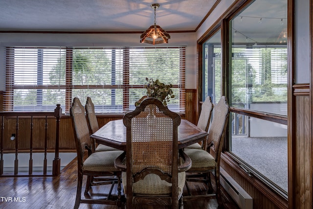 dining area with a textured ceiling, crown molding, plenty of natural light, and dark wood-type flooring