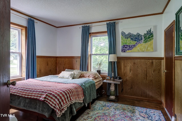 bedroom with dark hardwood / wood-style floors, a textured ceiling, and multiple windows