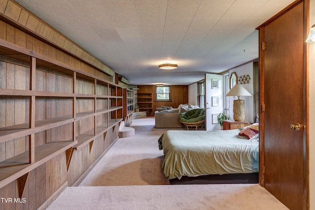 bedroom featuring light carpet and wooden walls