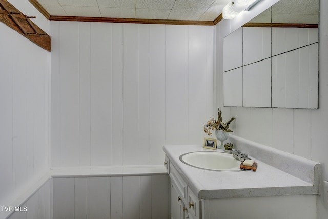 bathroom featuring vanity and wooden walls