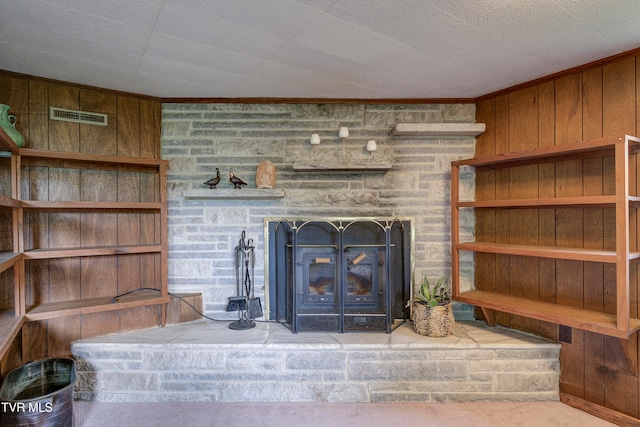 details with wood walls, a fireplace, carpet, and ornamental molding