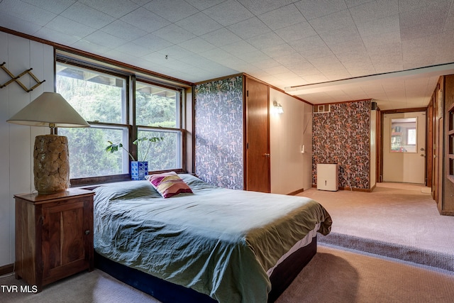 bedroom featuring carpet, crown molding, and multiple windows