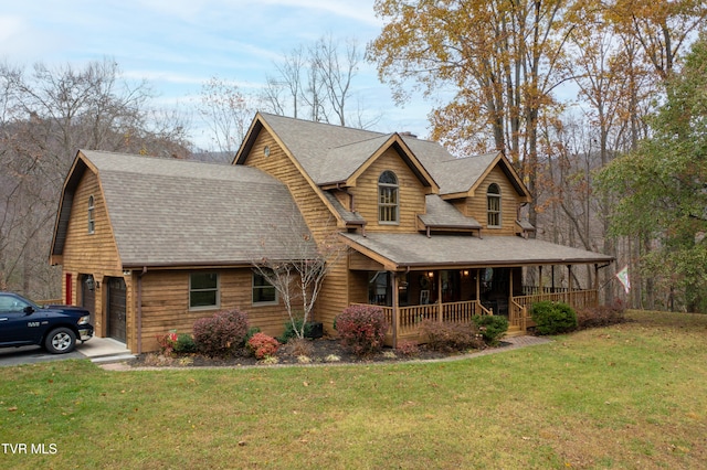 view of front of home featuring a porch, a garage, and a front lawn