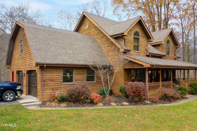 view of front facade with a garage, covered porch, and a front lawn