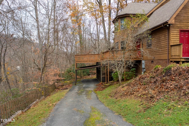 view of property exterior featuring a carport and a deck