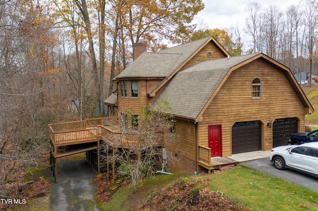 cabin featuring a wooden deck and a garage