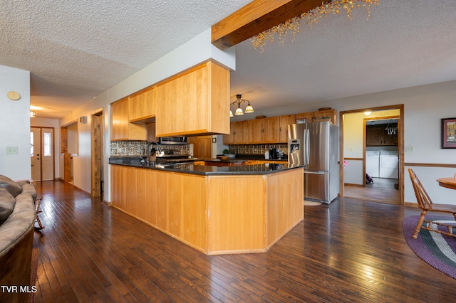 kitchen featuring dark hardwood / wood-style flooring, kitchen peninsula, backsplash, and appliances with stainless steel finishes