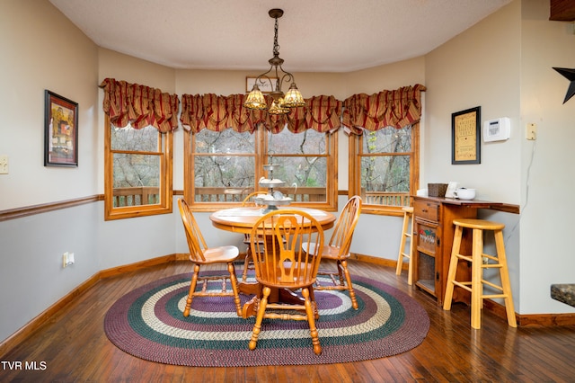 dining room with dark hardwood / wood-style flooring and a notable chandelier