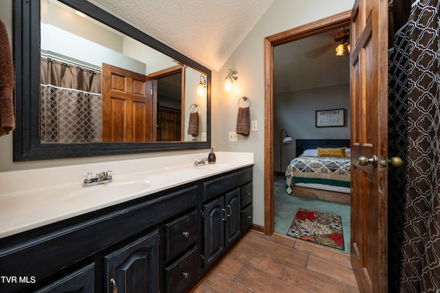 bathroom with vanity, lofted ceiling, hardwood / wood-style flooring, ceiling fan, and a textured ceiling