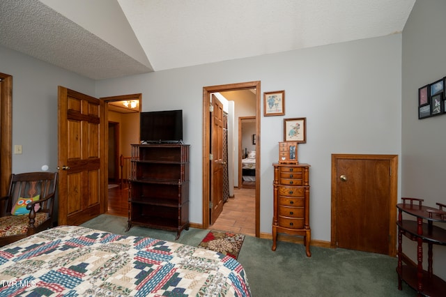 bedroom featuring lofted ceiling, a textured ceiling, and light carpet