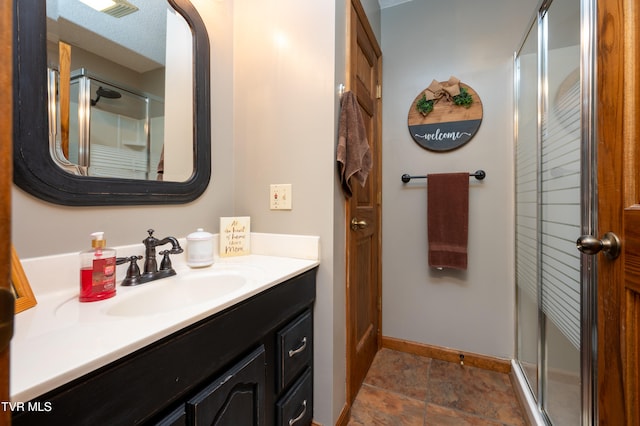 bathroom featuring a textured ceiling, vanity, and an enclosed shower