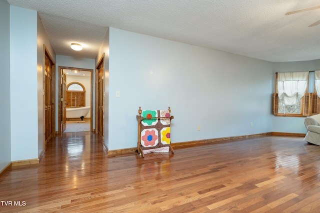 spare room with light hardwood / wood-style flooring and a textured ceiling