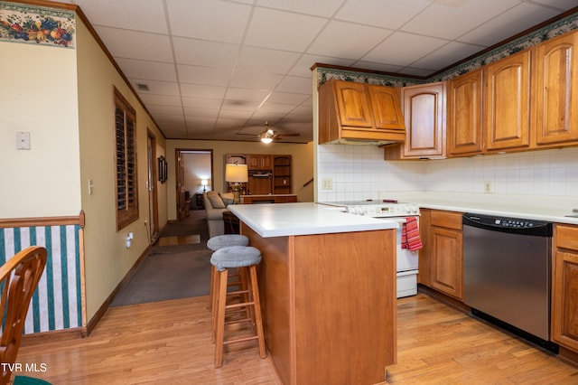 kitchen featuring dishwasher, custom exhaust hood, light hardwood / wood-style floors, white range oven, and a breakfast bar area