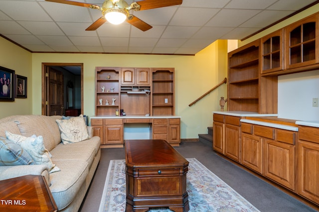 carpeted living room with ceiling fan and a drop ceiling