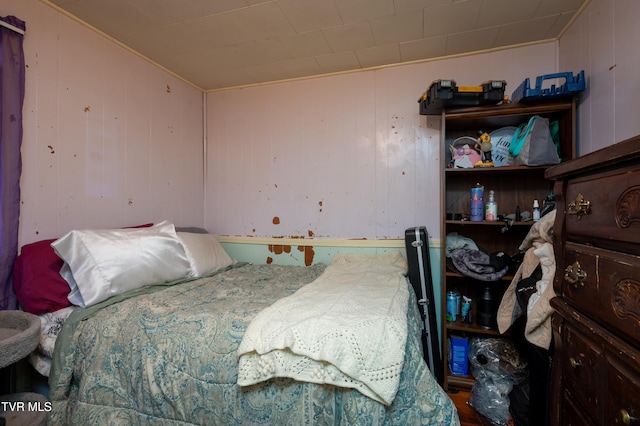 bedroom featuring wooden walls