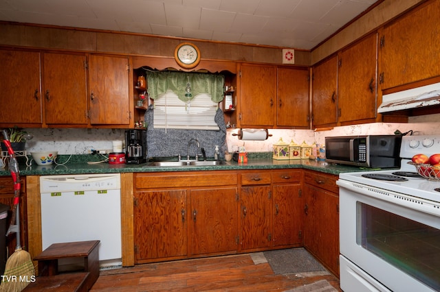 kitchen featuring dark hardwood / wood-style flooring, white appliances, sink, and tasteful backsplash