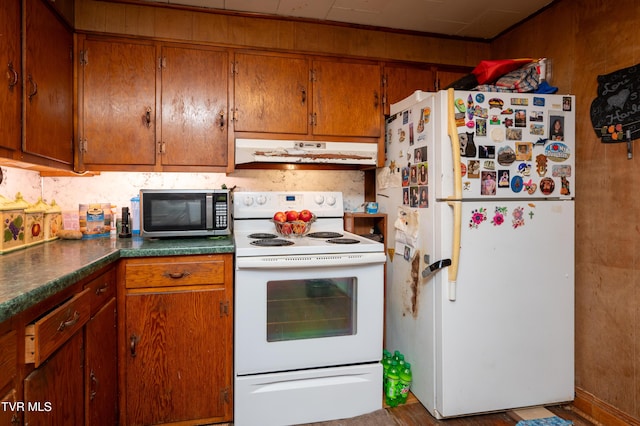 kitchen with hardwood / wood-style floors, white appliances, and wooden walls