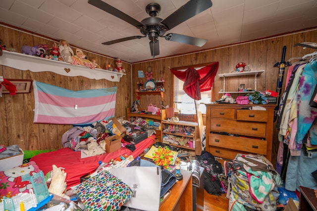 bedroom featuring ceiling fan and wooden walls