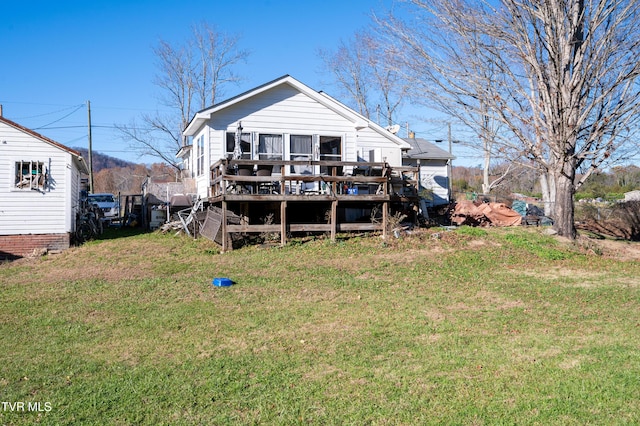 rear view of house with a lawn and a wooden deck