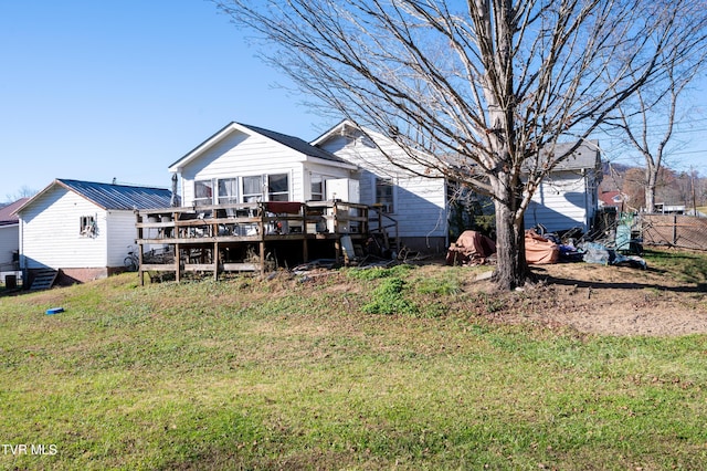 rear view of property featuring a yard and a wooden deck