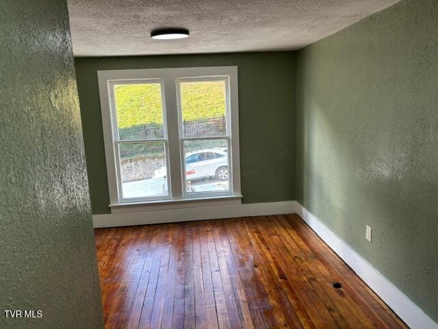 unfurnished room featuring hardwood / wood-style floors and a textured ceiling