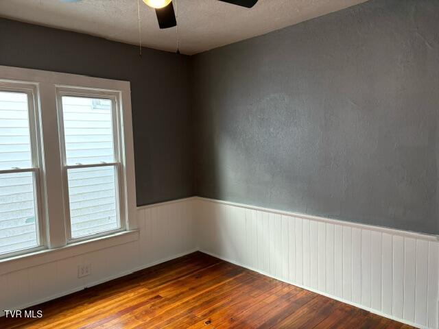 911 Russell St, Bristol, VA 24201 - spare room with a ceiling fan, hardwood / wood-style flooring, a textured ceiling, and a wainscoted wall