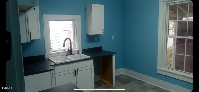 911 Russell St, Bristol, VA 24201 - kitchen featuring fridge, dark countertops, and white cabinets