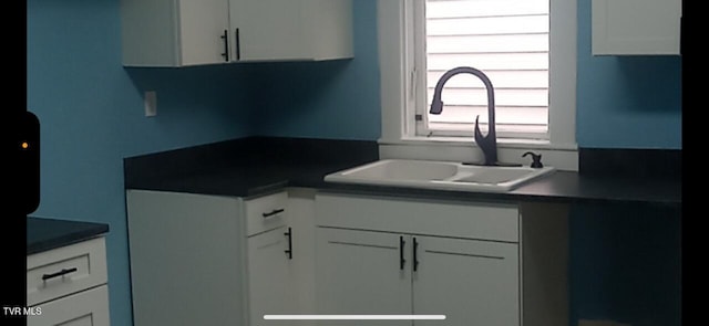 911 Russell St, Bristol, VA 24201 - kitchen featuring white cabinets and dark countertops