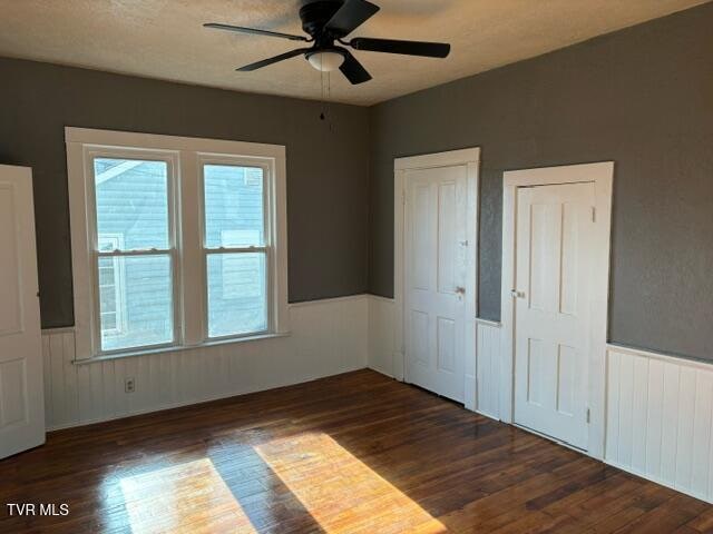 unfurnished bedroom with ceiling fan and dark hardwood / wood-style floors