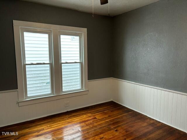 empty room featuring ceiling fan and dark wood-type flooring