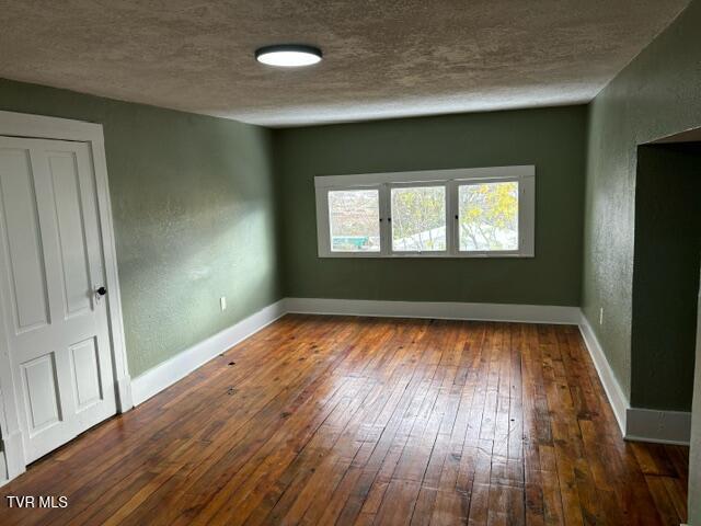 911 Russell St, Bristol, VA 24201 - spare room featuring wood-type flooring and a textured ceiling