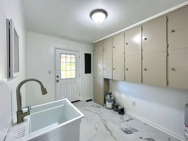 entryway with crown molding, sink, and a textured ceiling