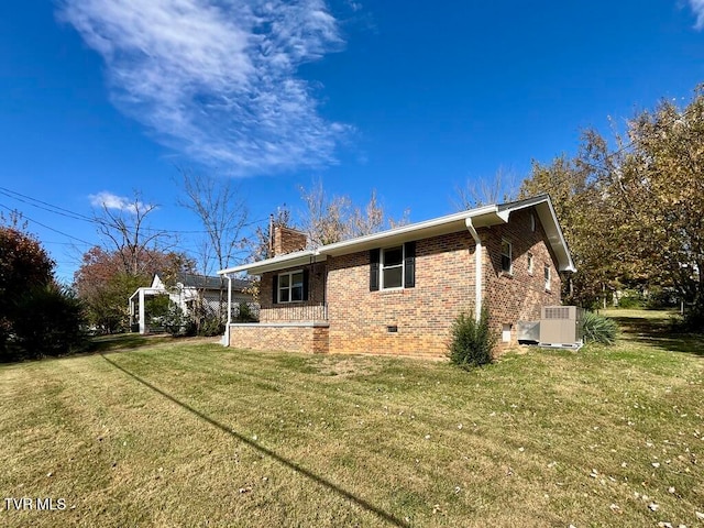 view of side of home featuring a yard and central AC