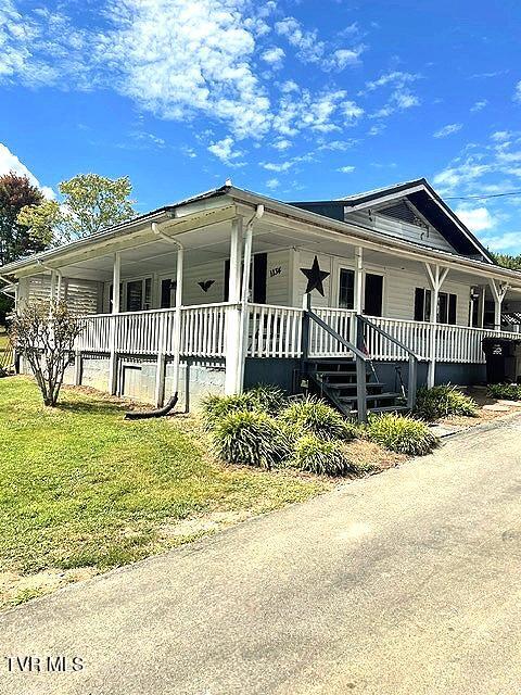 view of front facade featuring covered porch and a front yard