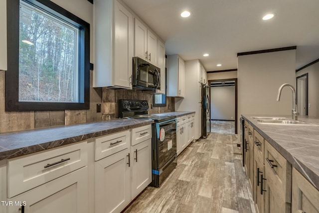 kitchen with sink, decorative backsplash, black appliances, and white cabinets