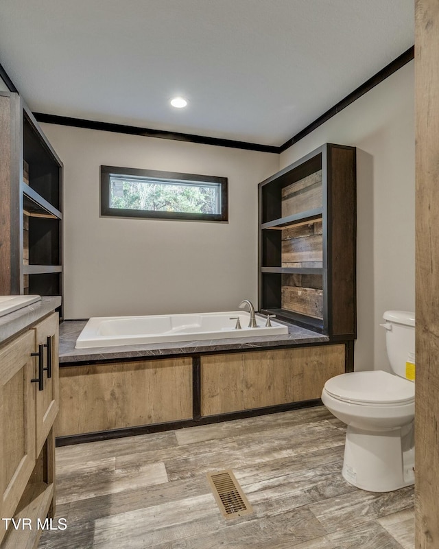 bathroom featuring a bath, crown molding, and hardwood / wood-style flooring