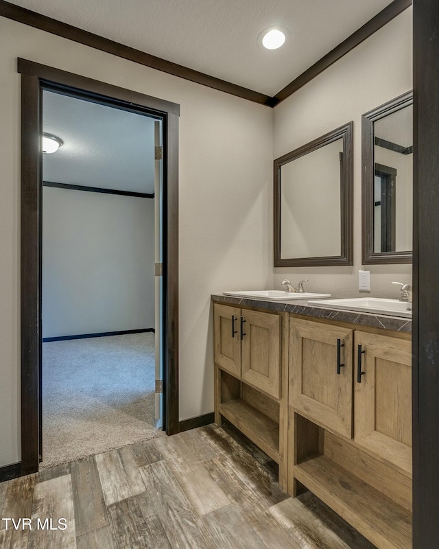 bathroom with hardwood / wood-style flooring, vanity, ornamental molding, and a textured ceiling