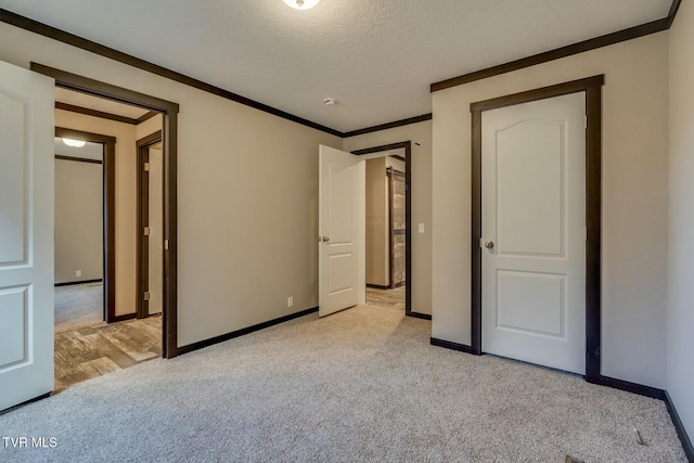 unfurnished bedroom with ornamental molding, light carpet, and a textured ceiling