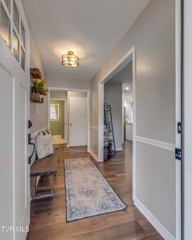 entryway with dark hardwood / wood-style flooring and a textured ceiling