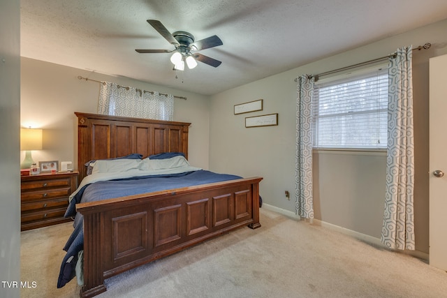 carpeted bedroom featuring ceiling fan and a textured ceiling