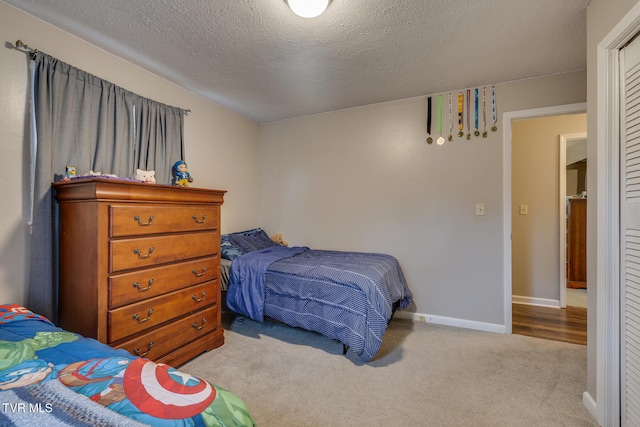 bedroom with a textured ceiling and light carpet