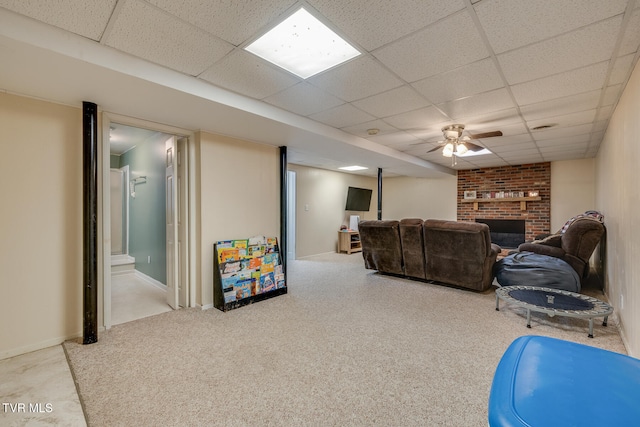 living room with a fireplace, a paneled ceiling, light colored carpet, and ceiling fan