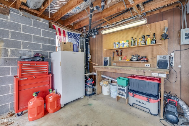 basement featuring a workshop area and white fridge