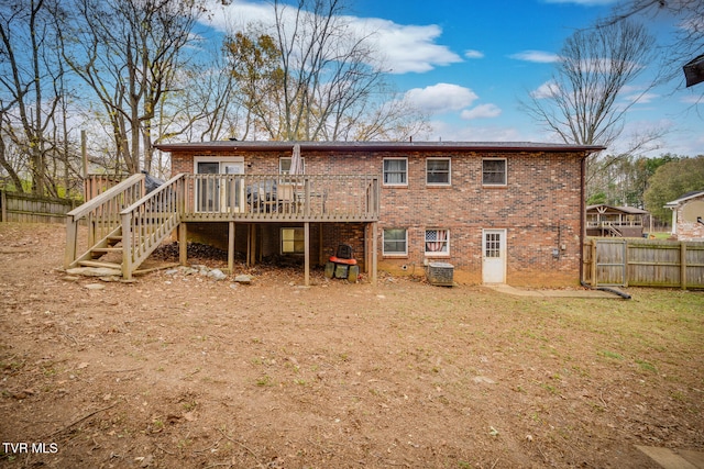 rear view of house featuring a lawn and a deck