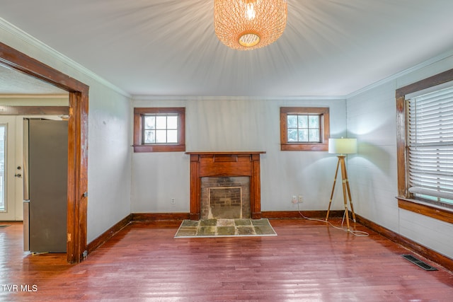 unfurnished living room featuring hardwood / wood-style floors, plenty of natural light, and crown molding