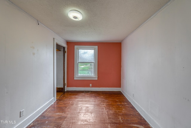 unfurnished room featuring a textured ceiling, crown molding, and dark hardwood / wood-style floors