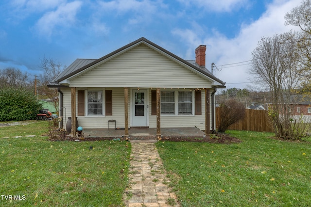 bungalow-style home with covered porch and a front yard